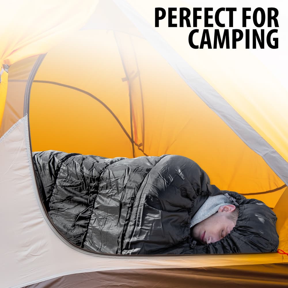Full image of a person sleeping in the Black Mummy Sleeping Bag. image number 1